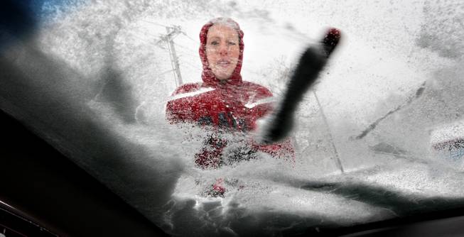 Shenandoah University student Kim Hyden of Staunton, Va. brushes several inches of snow from her windshield to head home after studying in the anatomy lab for her physician's assistant final exams in Winchester, Va. Sunday, Dec. 8, 2013. Rain, snow, sleet and freezing rain began to glaze most of the Mid-Atlantic on Sunday, with officials urging people to stay off the roads, as North Texas and other states shook off the early remnants of the powerful storm. (AP Photo, The Winchester Star, Jeff Taylor)